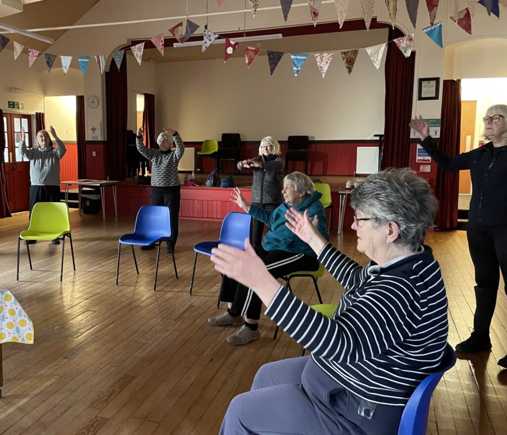 Wellness Group members seated and standing stretching